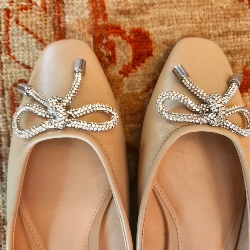 Nude-colored mules with sparkly bow detail